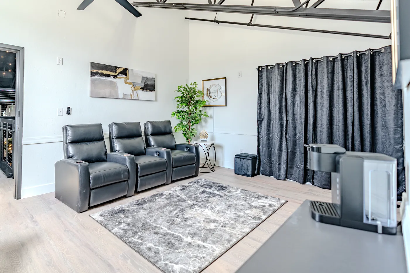 The Loft 102 groom suite with black leather theater seating and a TV lounge